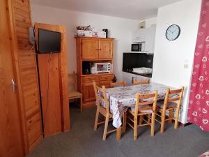 a kitchen with a table and chairs and a kitchen with a television at Appartement Saint-François-Longchamp, 2 pièces, 4 personnes - FR-1-635-54 in Saint-François-Longchamp