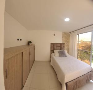 - une chambre avec un lit et une grande fenêtre dans l'établissement El samán, à Cartago