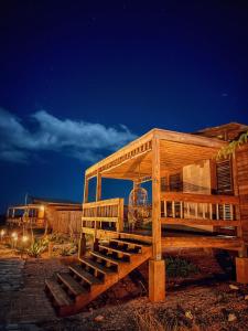 a wooden building with a deck at night at Eco Del Mar in Pedernales