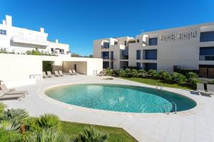 a swimming pool in front of a building at Luxurious & Premium Flat - Pool & Gym in Tavira