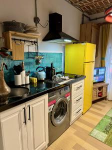 Il comprend une cuisine équipée d'un lave-linge et d'un réfrigérateur jaune. dans l'établissement Heristage Istanbul Galataport, à Istanbul