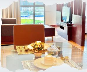 a living room with a table with a plate of food at Studio Exclusive Swimming pool view by HERITAGE SUITES Near IMAGO Mall City Central , FREE HIGHSPEED WIFI & NETFLIX , KOTA KINABALU in Kota Kinabalu