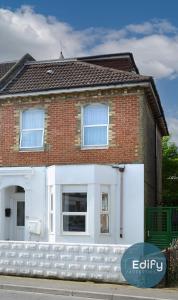 a red brick house with a white garage at Spacious Flat In City Centre With Garden in Southampton