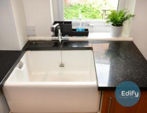 a white sink in a kitchen with a window at Spacious Flat In City Centre With Garden in Southampton