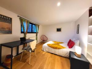 a bedroom with a bed and a desk with a laptop at 360 : Superbe maison, rooftop, vue Tour Eiffel, T2 in Meudon