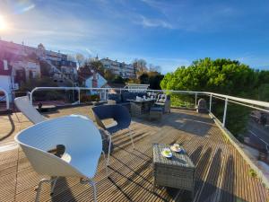 a deck with chairs and tables on a balcony at 360 : Superbe maison, rooftop, vue Tour Eiffel, T2 in Meudon