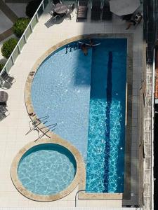 uma vista superior de uma piscina num edifício em Condo c/2 Suites a 200m da Beira Mar - Vista Mar em Fortaleza