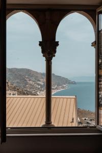 ein offenes Fenster mit Blick auf ein Gebäude in der Unterkunft Splendid Hotel Taormina in Taormina