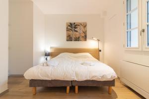 una camera con letto e testiera in legno di Wonder Appart' 402 - Vue sur Garonne a Tolosa