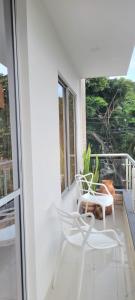 ein weißer Stuhl auf einem Balkon neben einem Fenster in der Unterkunft El samán in Cartago