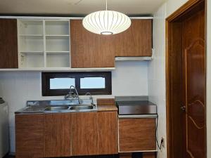 a kitchen with wooden cabinets and a sink and a light at Jamsil Geram in Seoul