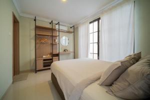 a bedroom with a large bed and a window at Danka@tudor residence in Batam Center