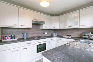 a kitchen with white cabinets and a counter top at Kime Contractor & Holiday Home in Lincolnshire