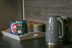 a cup of coffee and a box of milk on a table at Kime Contractor & Holiday Home in Lincolnshire