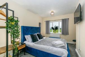 a bedroom with a blue bed and a window at Kime Contractor & Holiday Home in Lincolnshire
