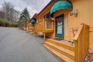 eine Hütte mit einer Veranda und einer grünen Tür in der Unterkunft Beech Mountain Condo with Community Pool and Game Room in Beech Mountain
