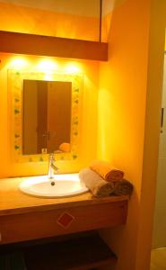 bagno con lavandino e specchio di Mabouya chez Villas Piment Café a Deshaies