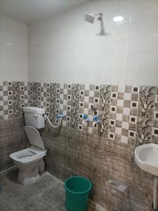 a bathroom with a toilet and a sink at Shri Gamya Guest House in Ujjain