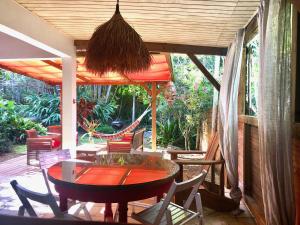 une terrasse couverte avec une table et des chaises. dans l'établissement Mabouya chez Villas Piment Café, à Deshaies