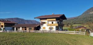 una casa con una valla delante de un campo en Haus Wurzenrainer, en Sankt Johann in Tirol