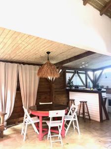 une salle à manger avec une table et des chaises rouges dans l'établissement Mabouya chez Villas Piment Café, à Deshaies