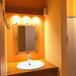 a bathroom with a sink and a mirror at Mabouya chez Villas Piment Café in Deshaies