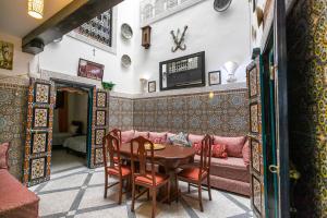 a living room with a table and a pink couch at 105 Kasbah de Boujloud Fes Morocco. in Fès