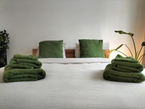 een bed met groene handdoeken erop bij Sea la vie in Oostende