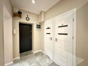 a hallway with a white closet and a door at MMRent New York Room in Gdańsk