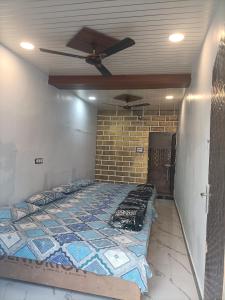 Ce lit se trouve dans un dortoir doté d'un ventilateur de plafond. dans l'établissement Shri Gamya Guest House, à Ujjain