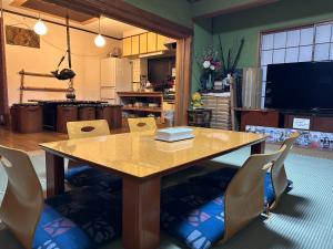 a dining room table with chairs and a television at Numazu Ikyuuan 沼津一休庵 in Numazu