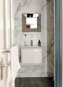 a white bathroom with a sink and a mirror at Anne Boleyn’s Escape in Deal