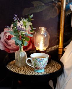 een tafel met een koffiekopje en een vaas met bloemen bij Anne Boleyn’s Escape in Deal