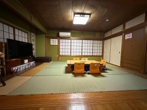 a room with a table and chairs and a tv at Numazu Ikyuuan 沼津一休庵 in Numazu