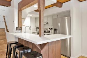 cocina con encimeras blancas y nevera de acero inoxidable en 2231-Summit View home, en Big Bear Lake
