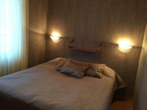 a bedroom with a bed with two lights on the wall at Mökki Ketunlenkki in Levi