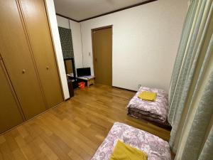 a living room with two beds and a television at Numazu Ikyuuan 沼津一休庵 in Numazu