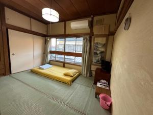 a small room with a bed and a window at Numazu Ikyuuan 沼津一休庵 in Numazu