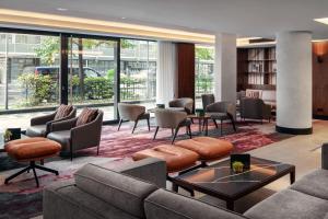 ein Wohnzimmer mit Sofas, Tischen und Stühlen in der Unterkunft Prague Marriott Hotel in Prag