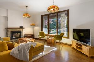 a living room with a couch and a tv at Villa Lana chalet Baros, Jaca in Jaca