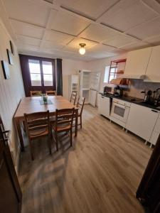 a kitchen with a wooden table and chairs in a room at Rigi-Scheidegg Ferienwohnungen West XL in Vitznau