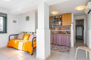 een slaapkamer met een bed en een keuken bij Seafront Apt with View in Aci Castello in Aci Castello