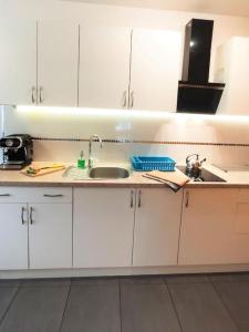 a kitchen with white cabinets and a sink at Apartamenty Pilsko in Korbielów