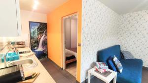 a bathroom with a sink and a blue couch in a room at Apartamenty Pilsko in Korbielów