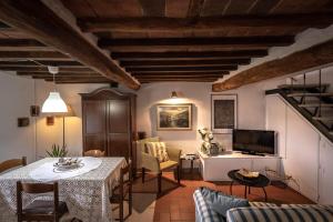 een woonkamer met een tafel en stoelen en een televisie bij La Colombaia in Massa e Cozzile