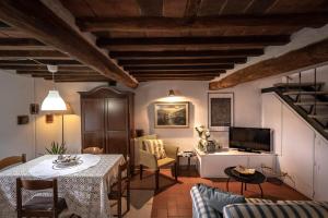 a living room with a table and chairs and a television at La Colombaia in Massa e Cozzile