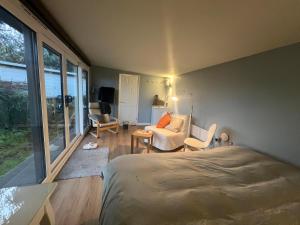 een slaapkamer met een bed en een woonkamer bij Henley Garden Studio in Henley on Thames