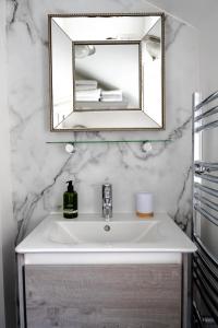 a bathroom with a white sink and a mirror at Anne Boleyn’s Escape in Deal +22 photos