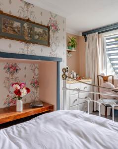 a bedroom with a bed and a table with flowers at Anne Boleyn’s Escape in Deal