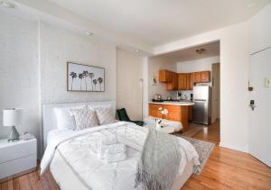 a bedroom with a white bed and a kitchen at Beautiful Studio Apartment At East Side in New York